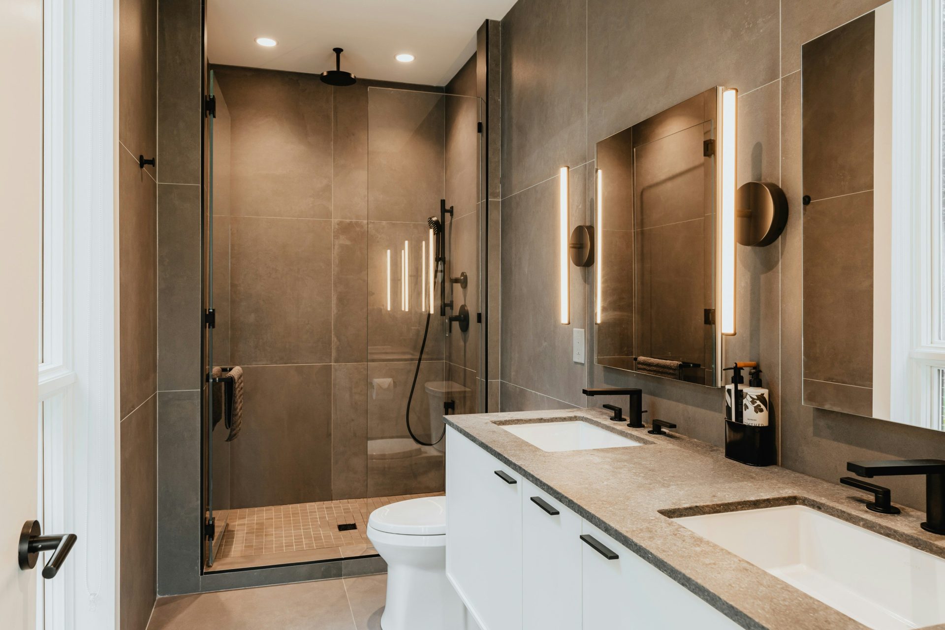 ein Badezimmer mit zwei Waschbecken, einer Toilette und einer Dusche